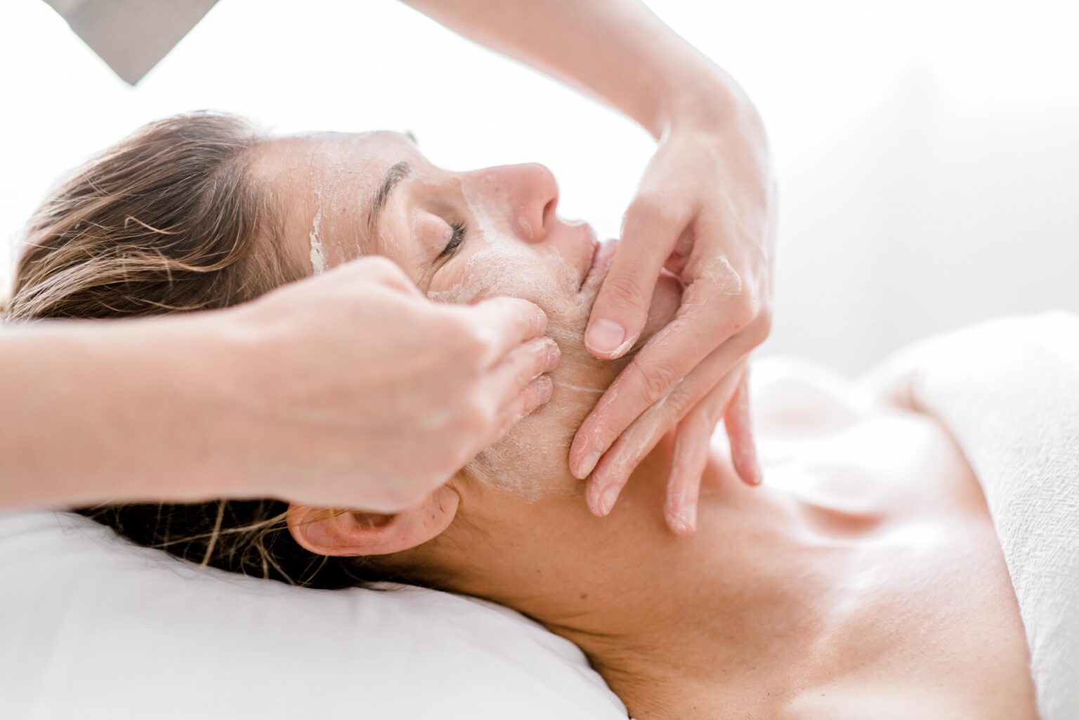 Woman-having-a-relaxing-facial-treatment-at-a-spa